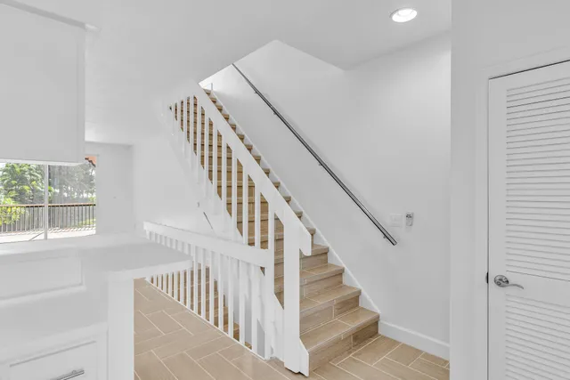 a view of staircase with wooden floor and white walls