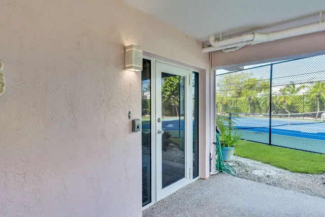 a view of backyard with large windows and plants