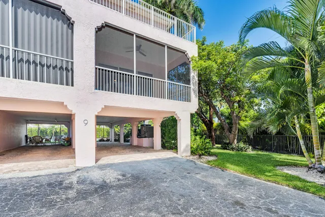 a view of a house with a yard and potted plants