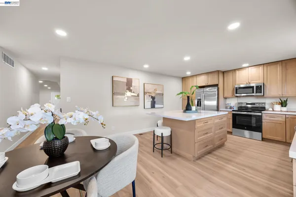 a living room with furniture kitchen and a wooden floor
