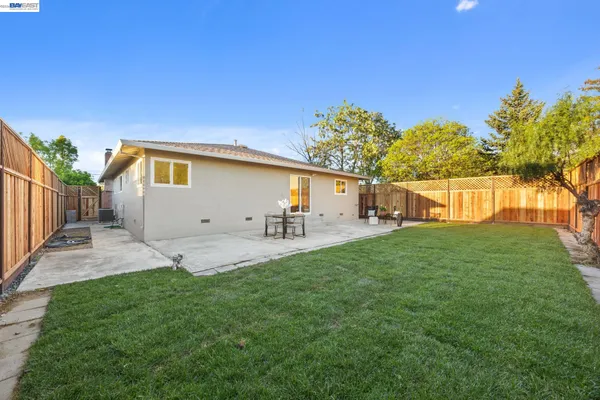 a front view of a house with a yard and a tree