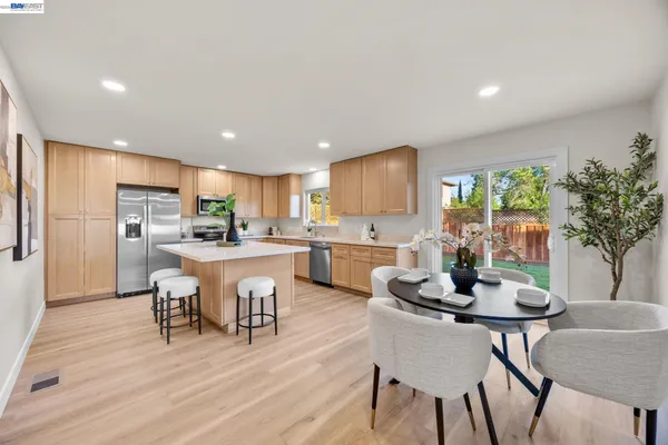 a kitchen with a dining table chairs and refrigerator
