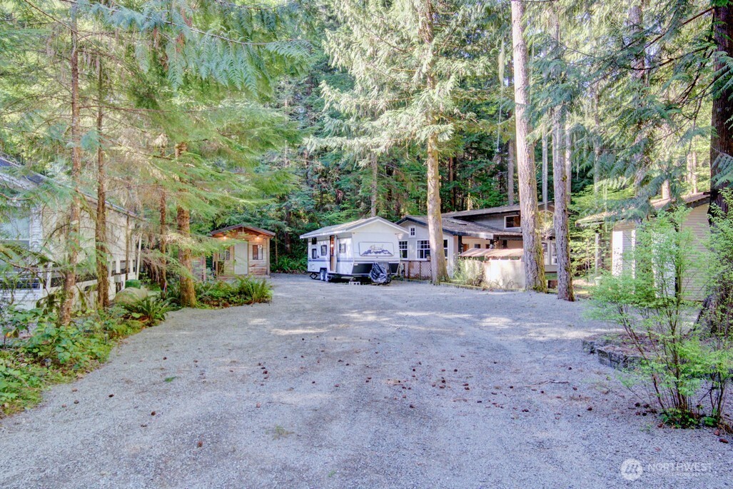106 Goldrush Road Deming, WA 98244 - Photo 1 of 35 a small yard with large trees and a wooden fence