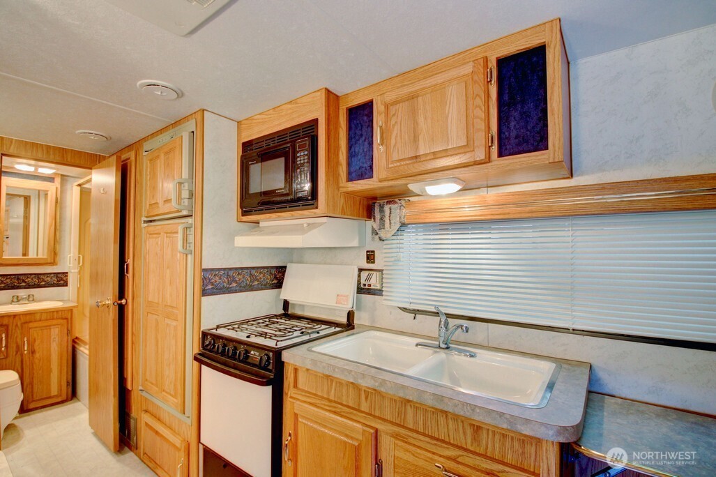 106 Goldrush Road Deming, WA 98244 - Photo 10 of 35 a kitchen with stainless steel appliances granite countertop a stove and a refrigerator