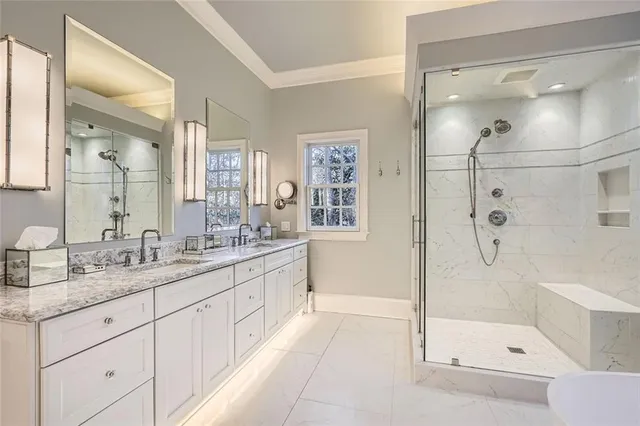 a bathroom with a double vanity sink toilet and shower