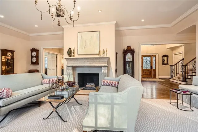a living room with furniture a fireplace and a chandelier