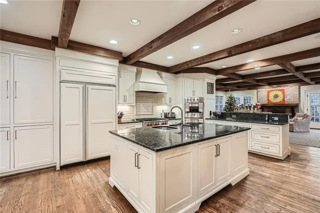 a kitchen with stainless steel appliances granite countertop a sink and a stove