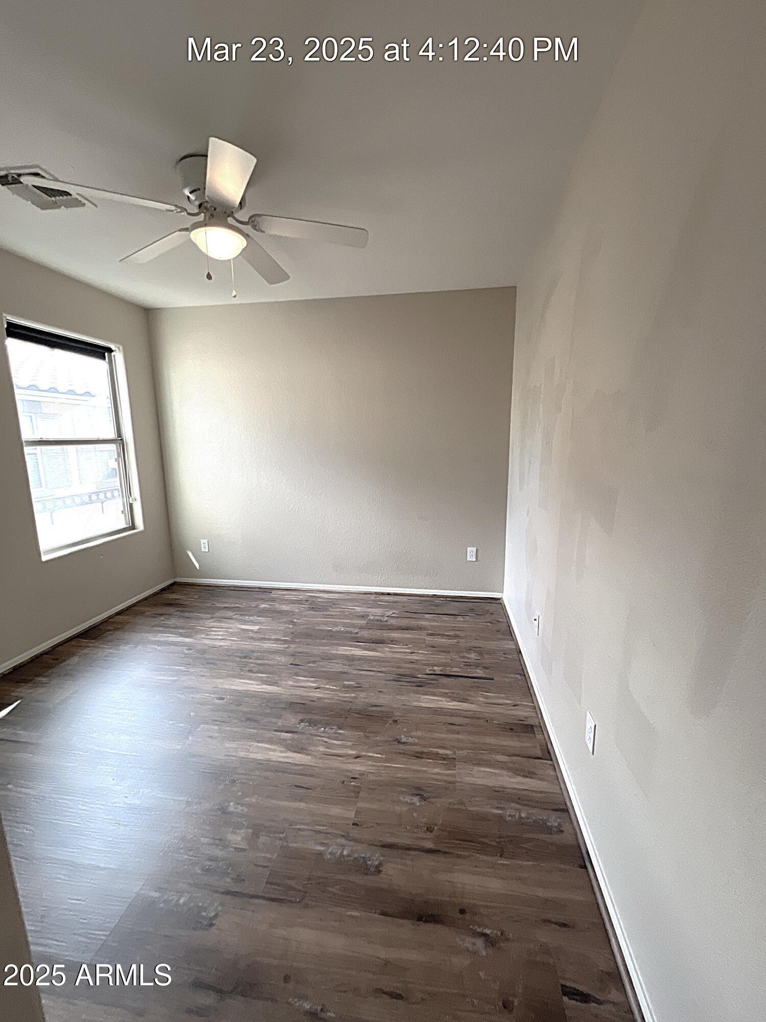 21183 East Avenida Del Valle Queen Creek, AZ 85142 - Photo 23 of 29 an empty room with wooden floor chandelier fan and windows