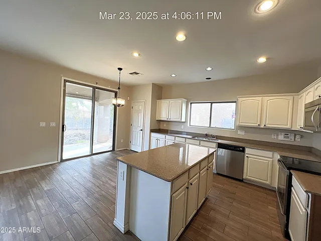 a kitchen with stainless steel appliances granite countertop a sink a stove and a wooden floors