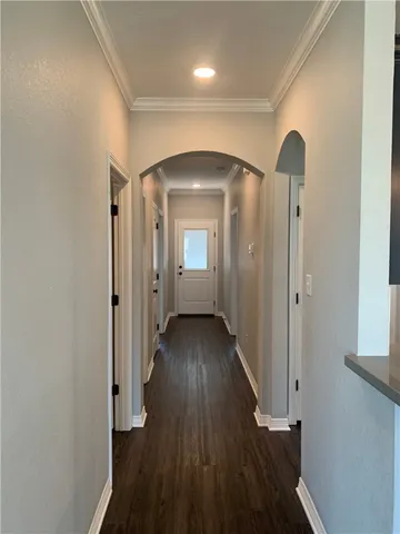 a view of a hallway with wooden floor and a bathroom
