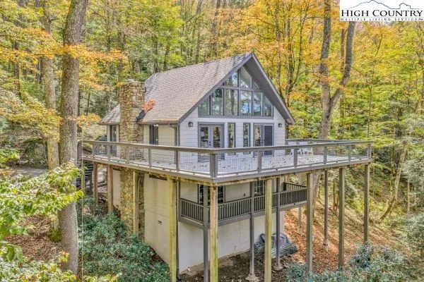 a view of a house with large windows and a small yard