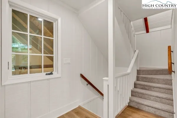 a view of staircase with wooden floor and windows