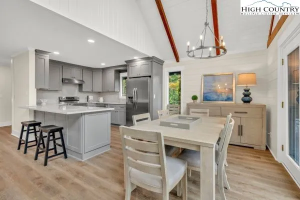 a kitchen with a dining table chairs and cabinets