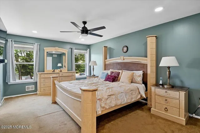 a spacious bedroom with a bed and a chandelier