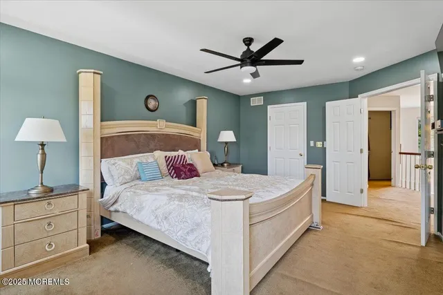 a spacious bedroom with a bed and a chandelier