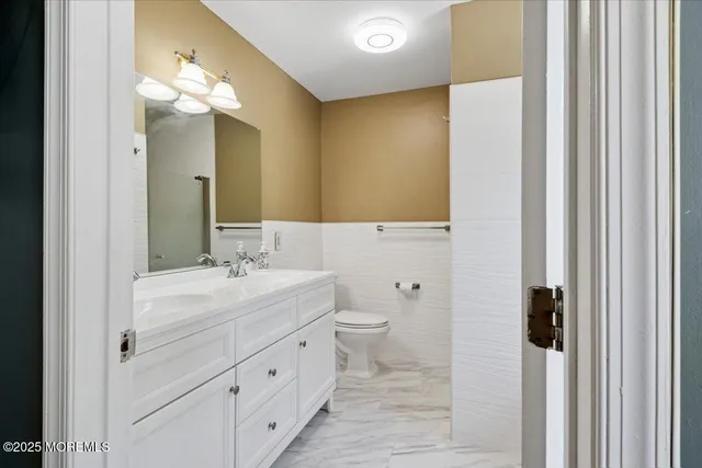 a bathroom with a double vanity sink a toilet and a mirror