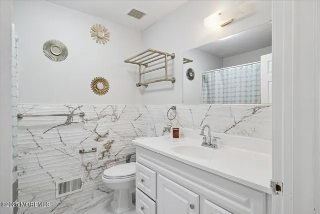 a bathroom with a sink mirror and toilet