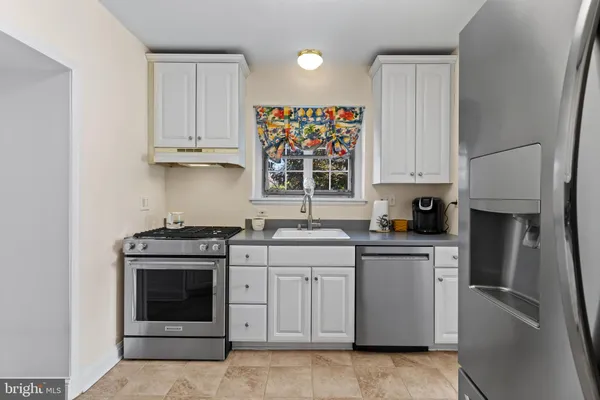 a kitchen with cabinets appliances and a window