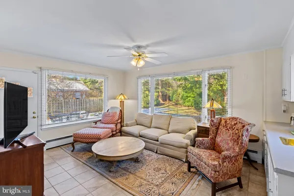 a living room with furniture a flat screen tv and a large window