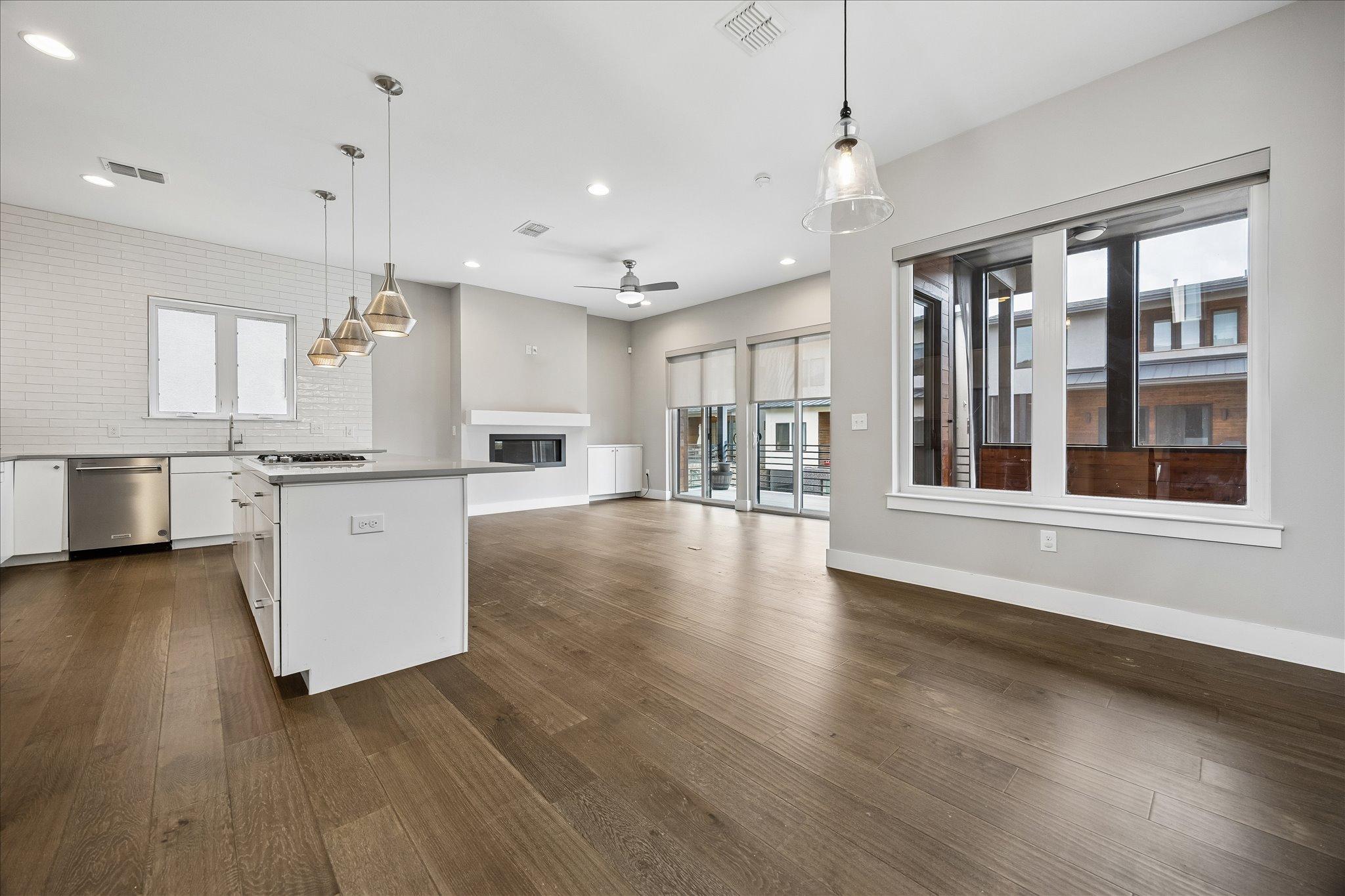 5006 Pecan Springs Road, Unit 6 Austin, TX 78723 - Photo 5 of 30 A spacious, open-concept living area with gleaming hardwood floors connects a modern kitchen and inviting fireplace.