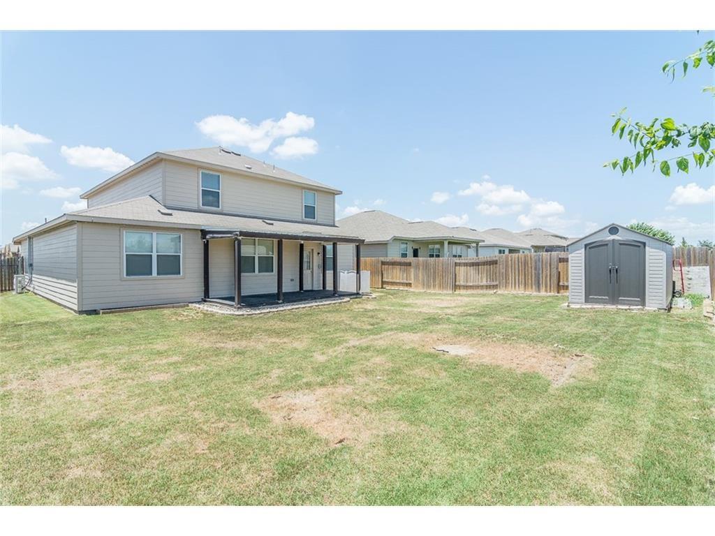 1009 Hawthorne Road Anna, TX 75409 - Photo 18 of 22 Two-story exterior with a covered patio, featuring light-toned siding and a fenced backyard