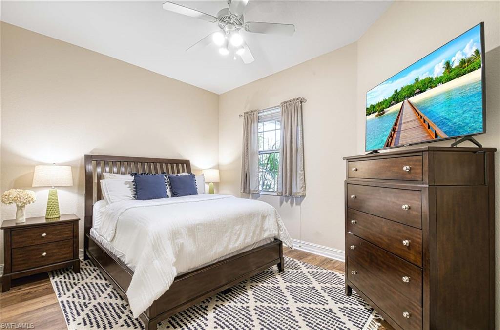 8649 Champions Point, Unit 1201 Naples, FL 34113 - Photo 15 of 23 Guest bedroom with wood grain luxury vinyl, lighted ceiling fan and oversized double closet.