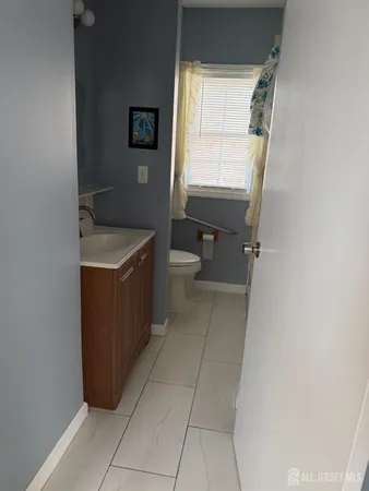 a bathroom with a sink a toilet and a window