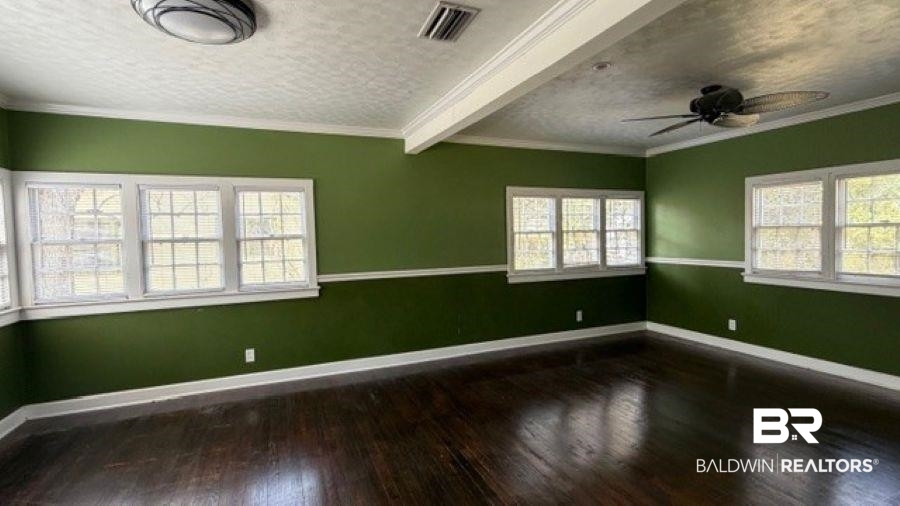 3006 Pleasant Valley Road Mobile, AL 36606 - Photo 15 of 20 Empty room featuring dark wood-type flooring, ceiling fan, ornamental molding, and a textured ceiling