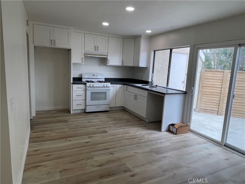 16 Gatewood Irvine, CA 92604 - Photo 4 of 12 a kitchen with granite countertop a stove a sink and a refrigerator