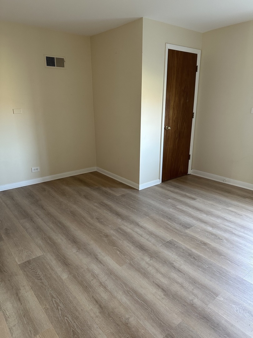 16664 West Aptakisic Road, Unit 1E Lincolnshire, IL 60069 - Photo 6 of 9 a view of an empty room with wooden floor