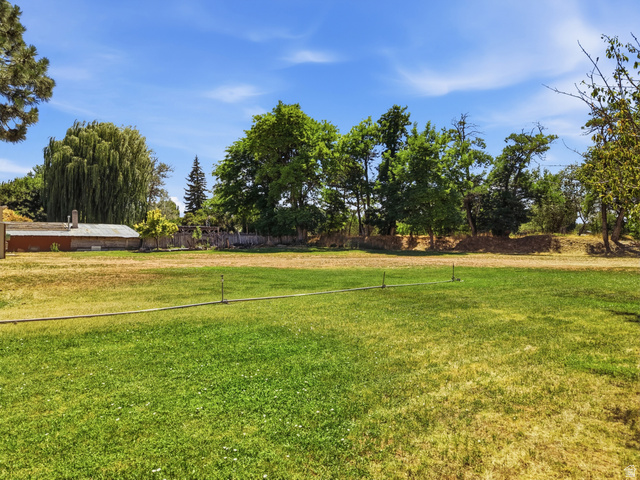 365 North Main Street Fillmore, UT 84631 - Photo 15 of 51 Spacious lawn area with mature trees and a distant building with a chimney