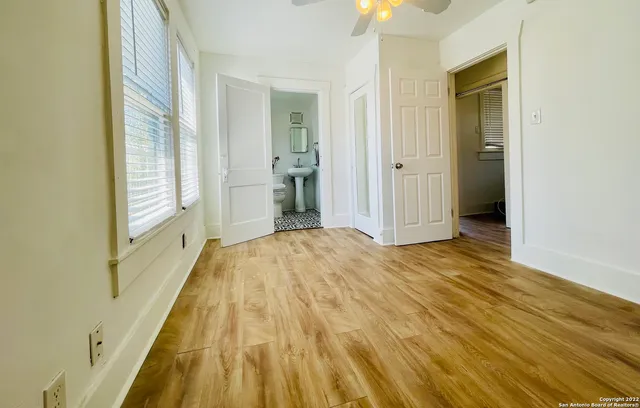 a view of a bedroom with wooden floor and bathroom