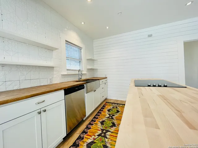 a kitchen with granite countertop white cabinets and white appliances