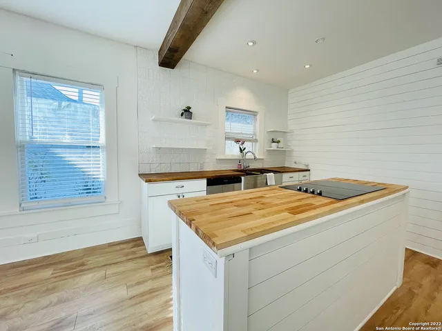a kitchen with a stove and a wooden floor