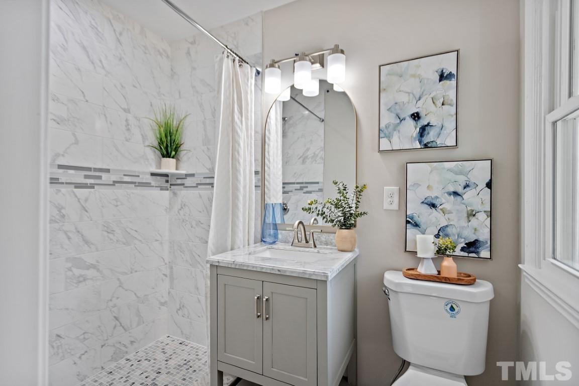 4116 Kilcullen Drive Raleigh, NC 27604 - Photo 14 of 28 a bathroom with a sink a mirror and a shower curtain