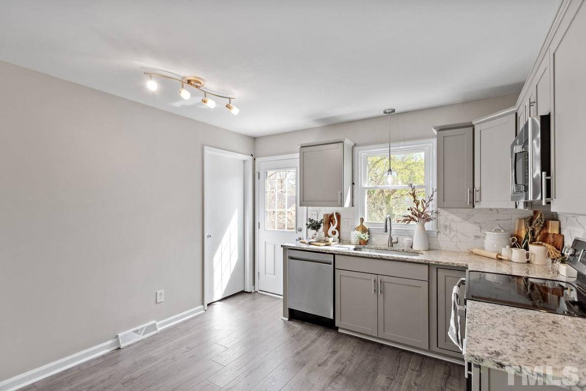 4116 Kilcullen Drive Raleigh, NC 27604 - Photo 4 of 28 a kitchen with a sink cabinets and wooden floor