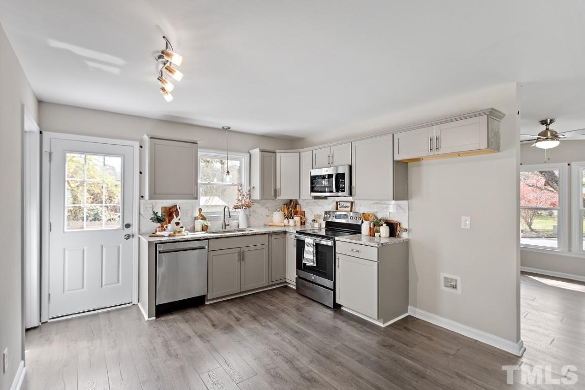 4116 Kilcullen Drive Raleigh, NC 27604 - Photo 5 of 28 a kitchen with appliances cabinets and a wooden floor