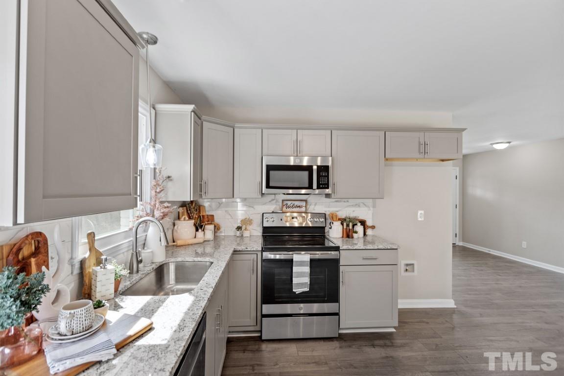 4116 Kilcullen Drive Raleigh, NC 27604 - Photo 6 of 28 a kitchen with stainless steel appliances a stove a sink and a refrigerator