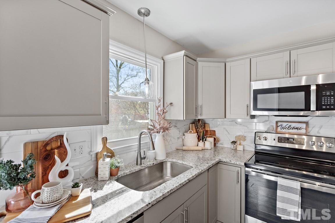 4116 Kilcullen Drive Raleigh, NC 27604 - Photo 7 of 28 a kitchen with stainless steel appliances a sink a stove and a microwave