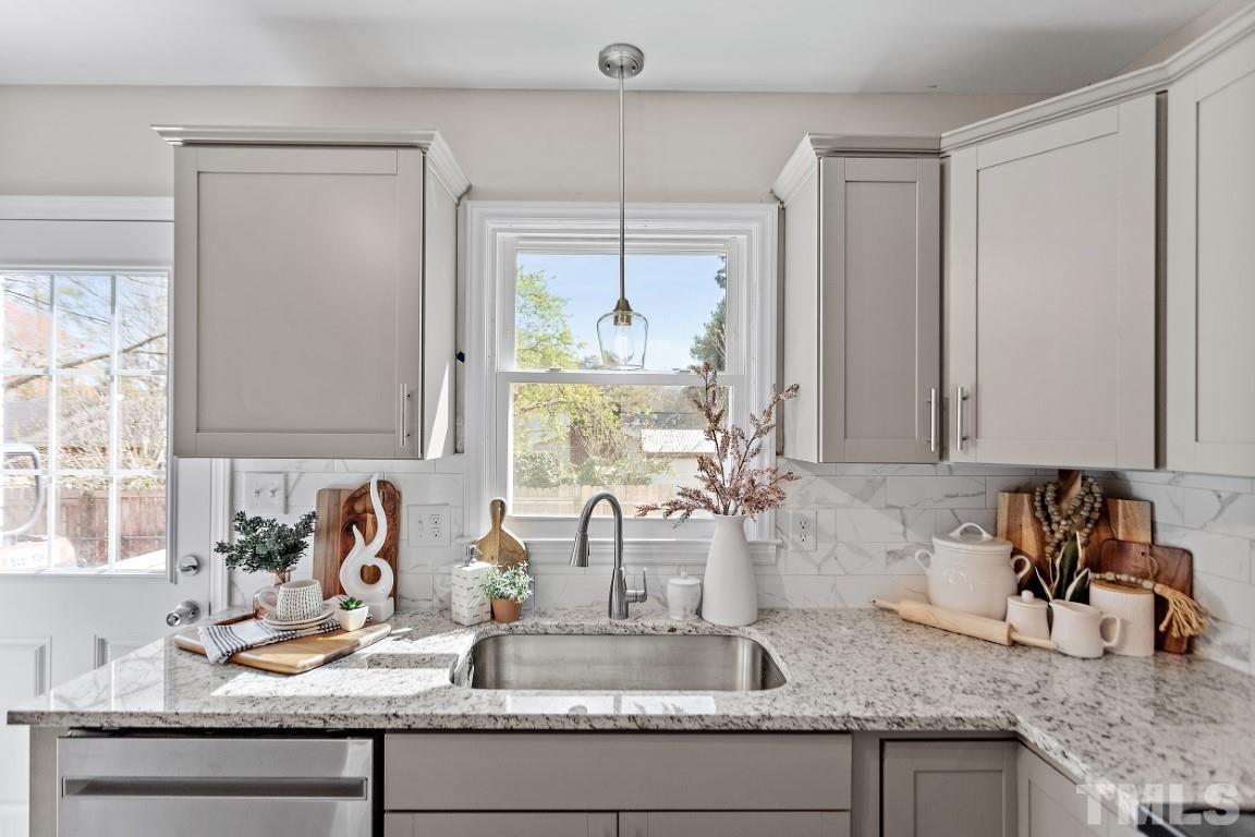 4116 Kilcullen Drive Raleigh, NC 27604 - Photo 8 of 28 a kitchen with granite countertop a sink a window and cabinets