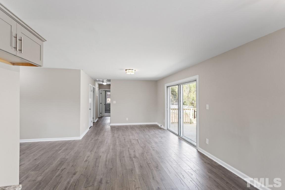 4116 Kilcullen Drive Raleigh, NC 27604 - Photo 9 of 28 a view of an empty room with wooden floor and window
