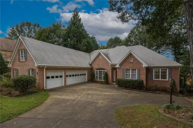 a front view of a house with a yard and trees