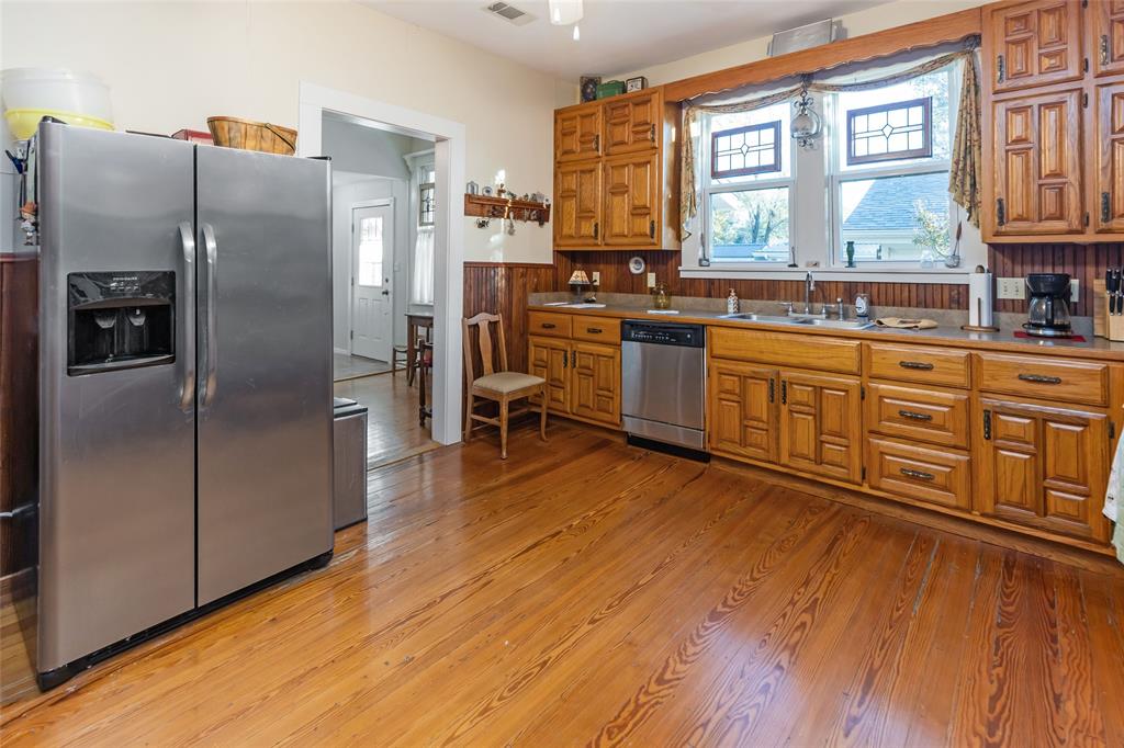 704 East Main Street Honey Grove, TX 75446 - Photo 19 of 38 a kitchen with stainless steel appliances a refrigerator sink and wooden floor