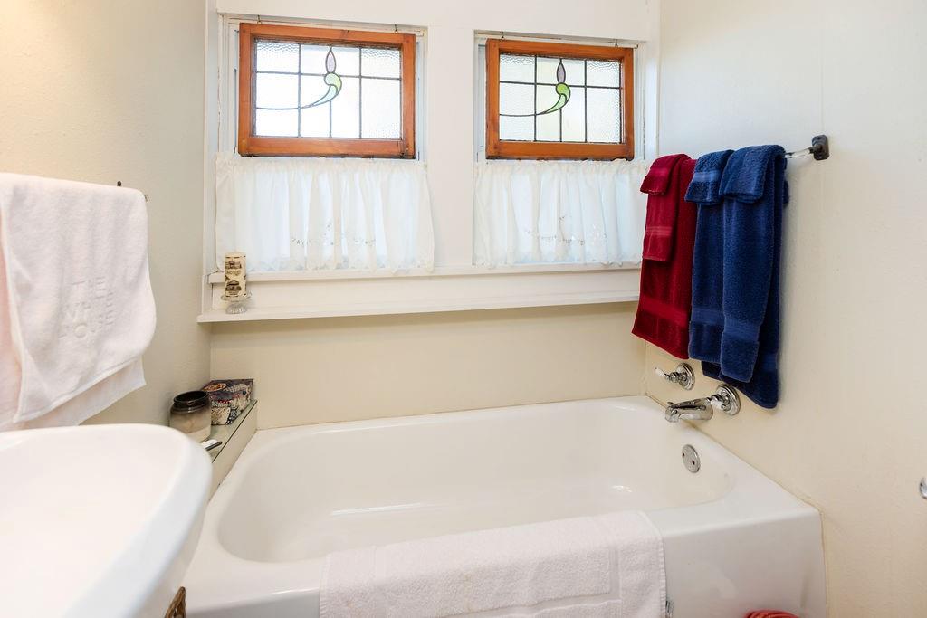 704 East Main Street Honey Grove, TX 75446 - Photo 32 of 38 a bathroom with a tub and a window