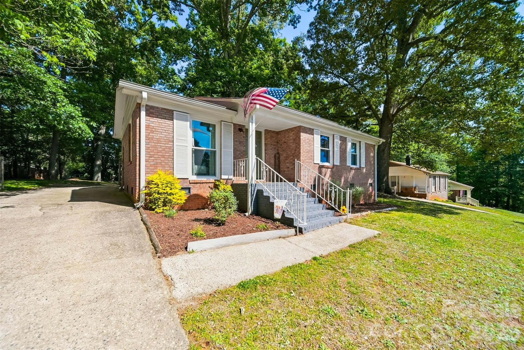 a front view of house with yard and trees in the background