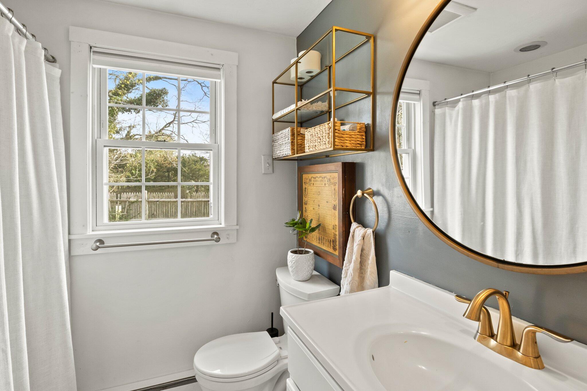 582 Massasoit Road Eastham, MA 02642 - Photo 14 of 45 a bathroom with a sink a toilet and a mirror