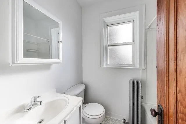 a bathroom with a sink vanity mirror and toilet
