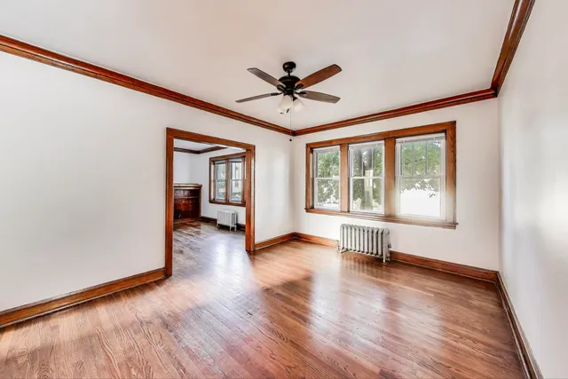 a view of a livingroom with wooden floor and a ceiling fan