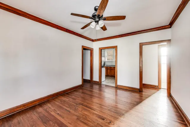a view of an empty room with window and wooden floor
