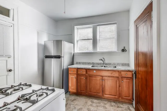 a kitchen with kitchen island granite countertop a sink stove and refrigerator